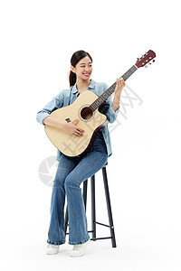 坐在椅子上弹吉他的青年女性图片