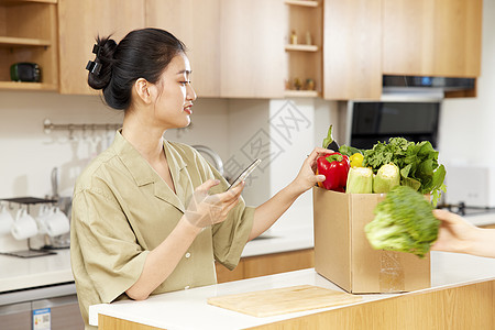 年轻女性居家线上团购蔬菜图片