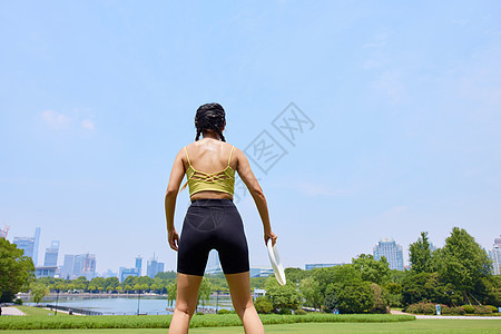 年轻美女玩飞盘背影图片