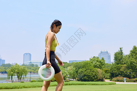 年轻女性拿着飞盘行走背景图片
