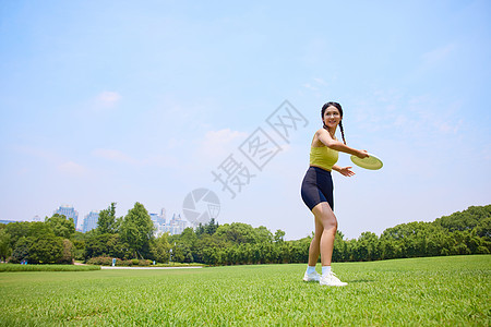 年轻美女在户外玩飞盘运动图片