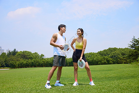 年轻男女户外飞盘运动图片