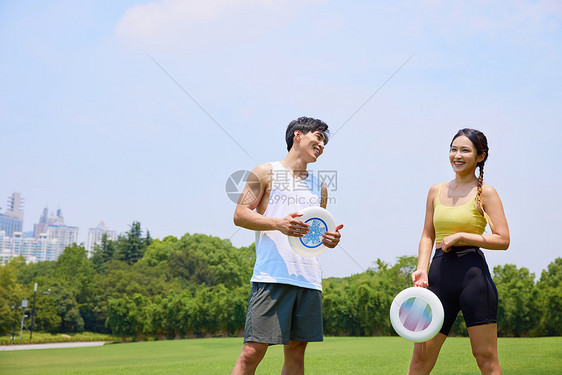 年轻男女在户外飞盘运动图片