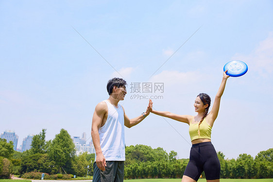 户外玩飞盘击掌的青年男女图片