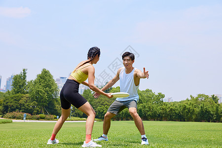 年轻男女户外玩飞盘图片