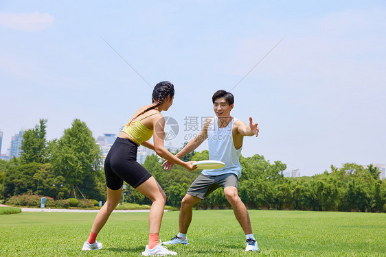 年轻男女户外玩飞盘图片