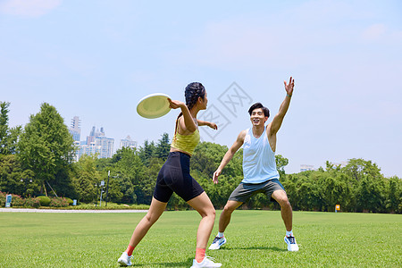 玩极限飞盘的年轻男女图片