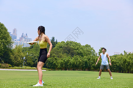 青年男女公园玩飞盘图片