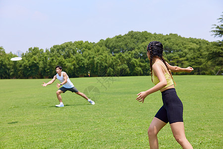 青年男女在公园玩飞盘图片