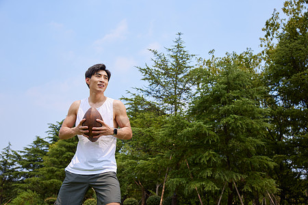 男青年户外玩橄榄球图片