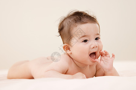 趴在床上玩耍的可爱婴儿背景图片