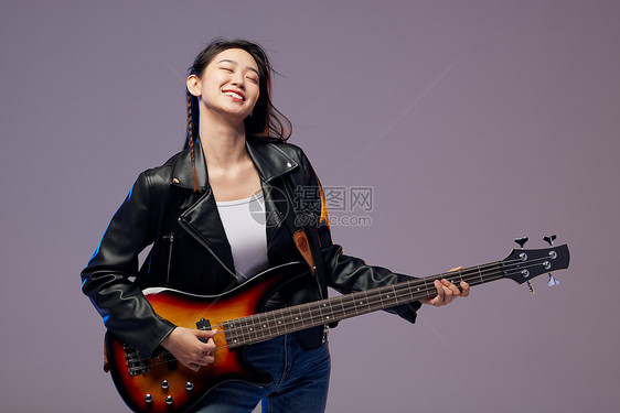 弹奏贝斯的摇滚活力女青年图片