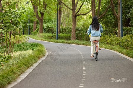 年轻女性户外骑行背影图片