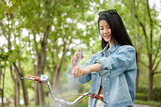 在室外骑行的美女使用补水喷雾图片