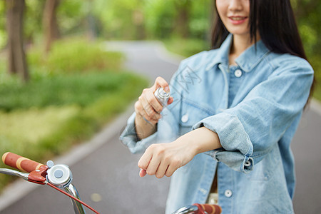 室外骑行的美女使用补水喷雾特写背景图片