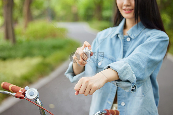 室外骑行的美女使用补水喷雾特写图片