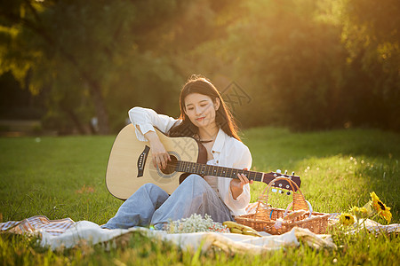 吉他美女元气美女草地上弹吉他背景