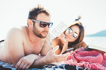 夏天在海边做日光浴的情侣图片