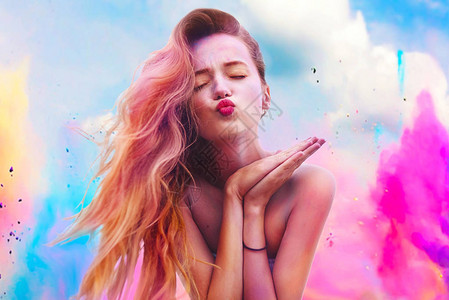 胡里节的颜色快乐的年轻漂亮女孩在洒红节色彩节上的画像女孩吻着五颜六色的长的粉红色和蓝色头发衣服上的彩色粉末涂料能量图片