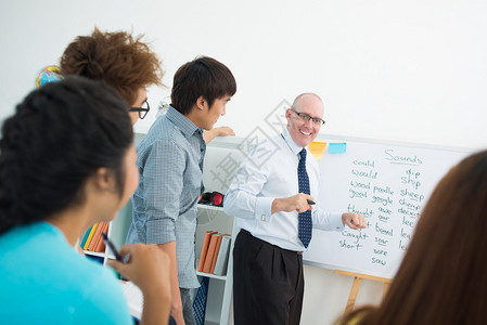 学生们试图猜测他们的老师在给一个提示的同时所图片