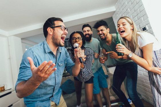 快乐的朋友们在家里一起唱歌卡拉O图片