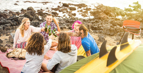 朋友背包客在海滩露营派对上一起玩乐快乐的友谊旅行概念与年轻人旅行者在夏季冲浪营弹吉他和喝啤酒温暖图片