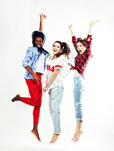 三个年轻漂亮的不同的少女朋友在白色背景下开心地笑着跳跃图片