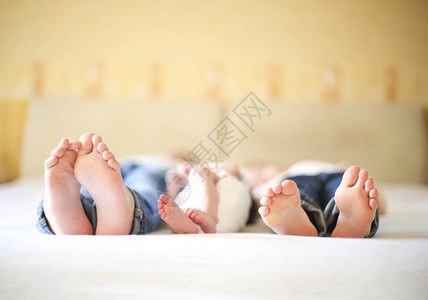 在床上的甜蜜家庭三姐妹双脚合拢假图片