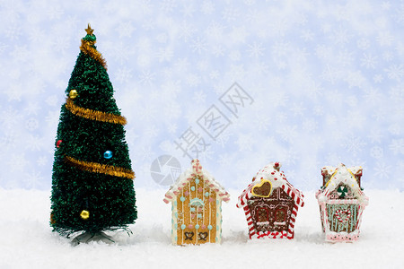 圣诞树和姜饼屋在雪花的圣诞图片