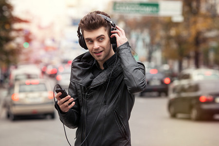 男人在街上用手机听歌图片