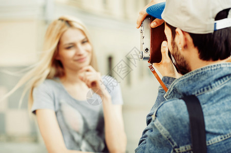 男生在给他的女朋友拍照图片