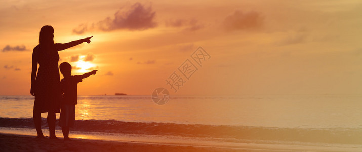 日落海滩母亲和儿子的背影指图片