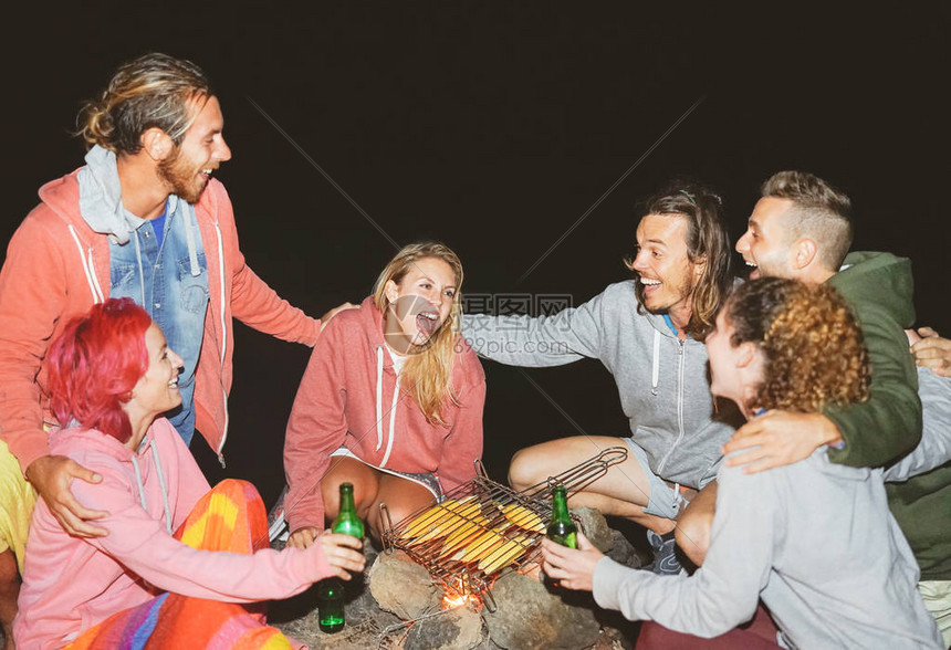 快乐的朋友在户外帐篷露营时开派对喝啤酒和演奏音乐图片