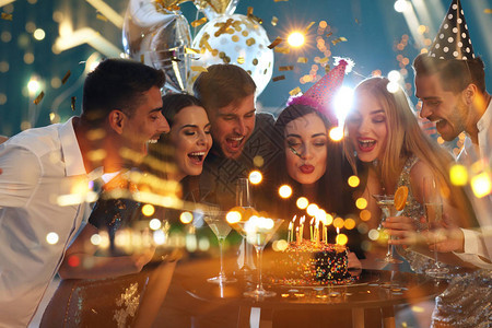 年轻人在生日晚会和夜间照明城市时双重于图片