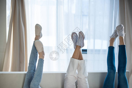 三名躺在沙发上双腿高的年轻妇图片