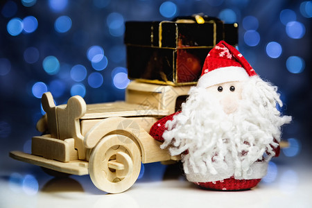 礼盒样机圣诞老人和老式木制汽车与圣诞灯背景上的礼品盒圣诞老人形象的主要焦点和带礼盒的左转背景
