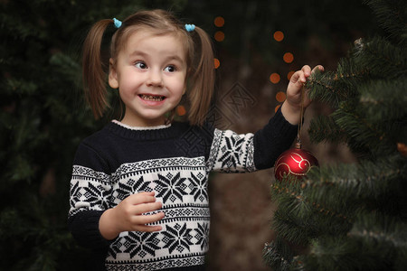 新年树旁的一个小孩子们装饰圣诞树婴儿在工作室的一棵绿树旁图片