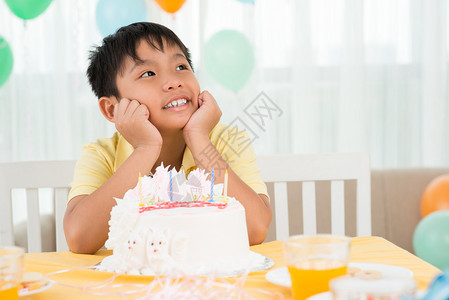 一个梦想的一天男孩坐在美味蛋糕前图片