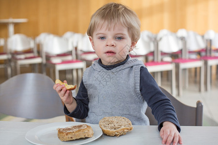 小男孩在幼儿园吃面包和苹果做早餐图片