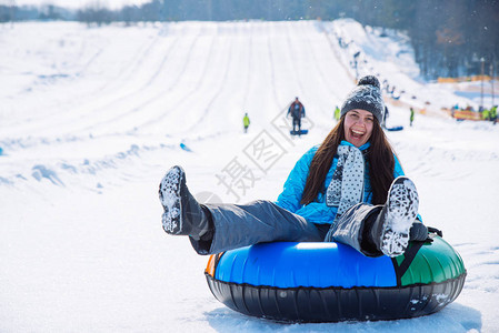 微笑的年轻女孩骑雪浴在山丘图片