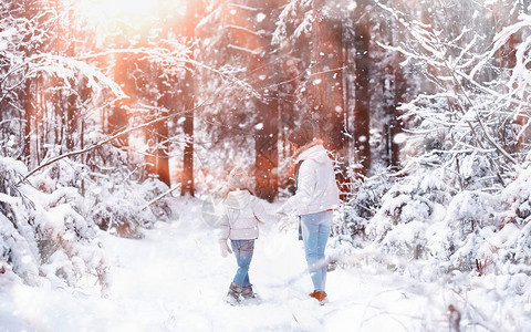 年轻妈妈年轻家庭散步妈和女儿在雪地公背景