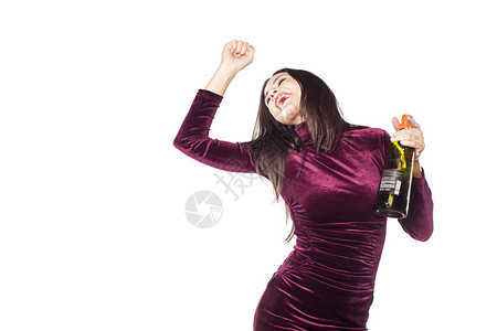 穿着紧身紫色礼服的嬉戏和快乐的年轻女子手上拿着一瓶图片