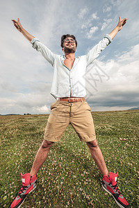 年轻时尚男子在草地上户外享受生活和自由图片