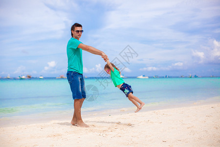 在热带白沙滩的热带白沙滩上年轻爸图片