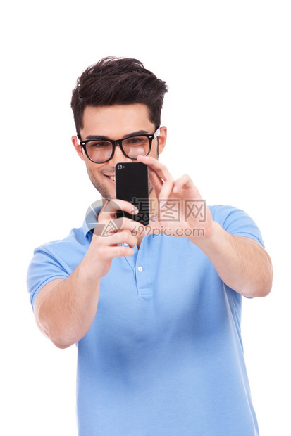 年轻笑着的闲人用手机照你的照片在白色背图片