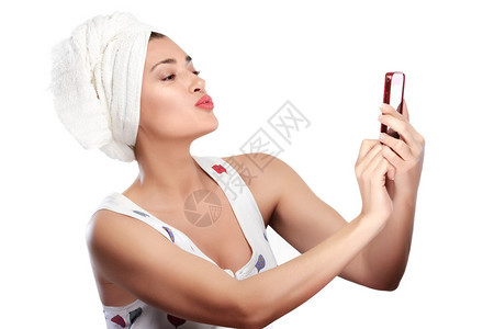 头戴毛巾的年轻女人用手机亲吻自己图片