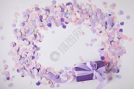 白色表面的礼品盒和紫色纸彩图片