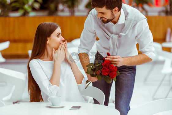 英俊的男人给女士准备了玫瑰花的惊喜图片