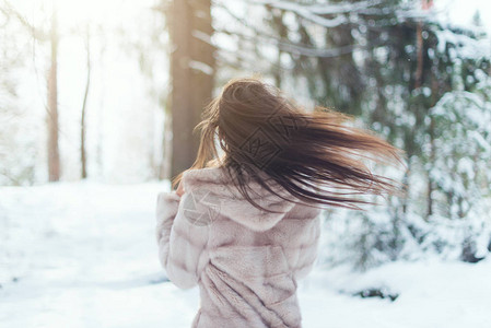 美丽的女人在下雪寒冷的冬日在森林里图片