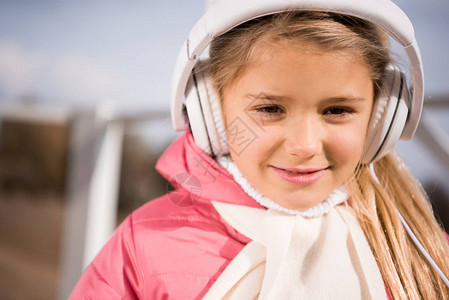 可爱笑的小女孩用白色耳机收听音乐图片